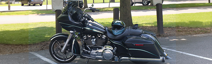 black classic cruiser parked in front of a tree