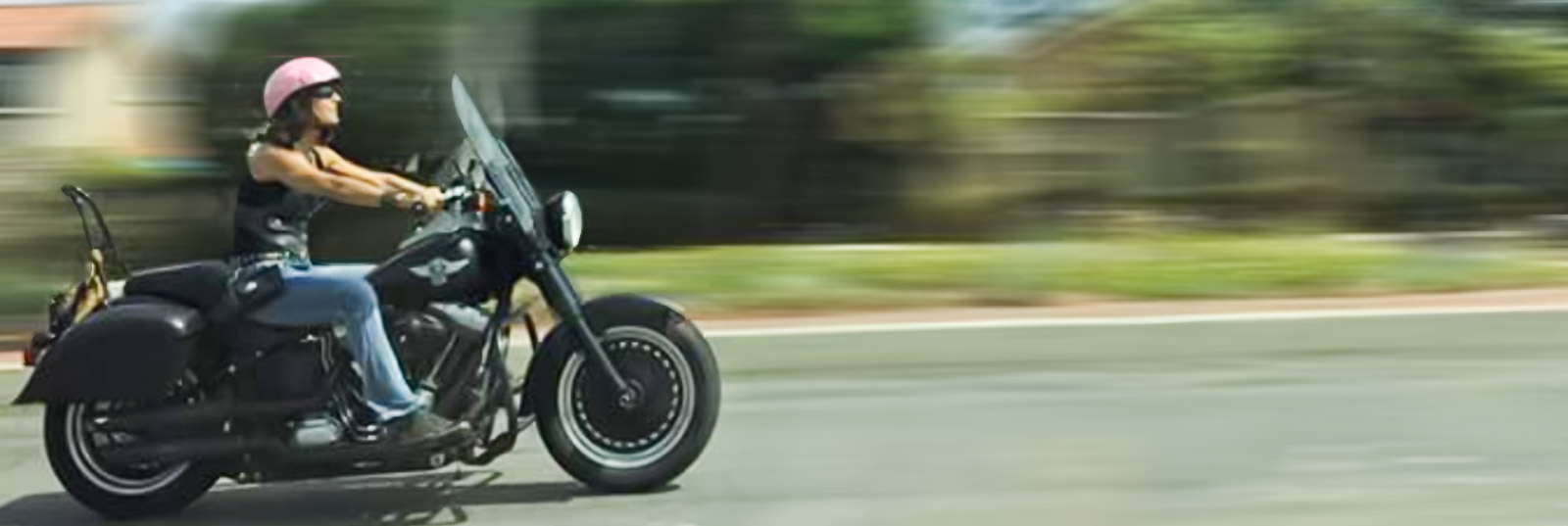 woman on motorcycle riding down street