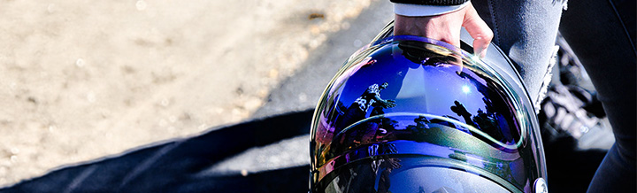 Motorcycle rider holding a type of helmet