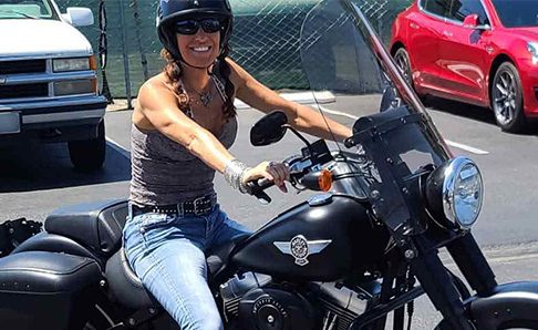 biker sitting on motorcycle in parking lot